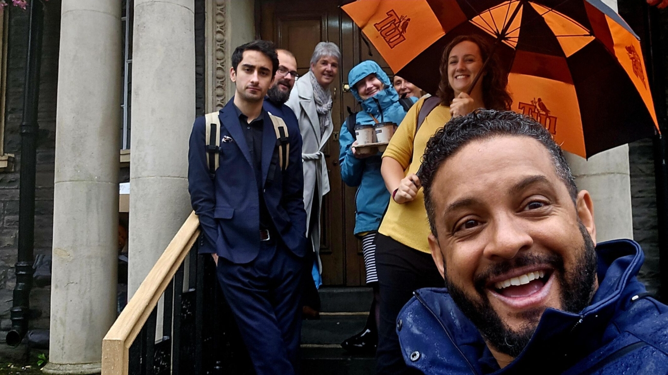 A group of people standing on the steps in the rain.